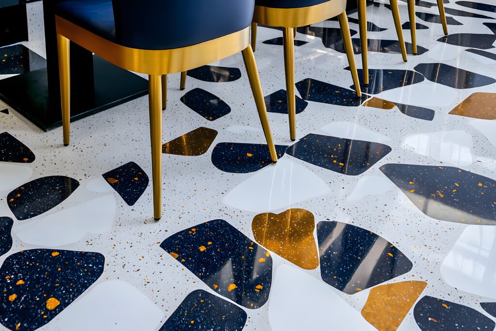 commercial bathroom terrazzo floor with navy, brass and white aggregate